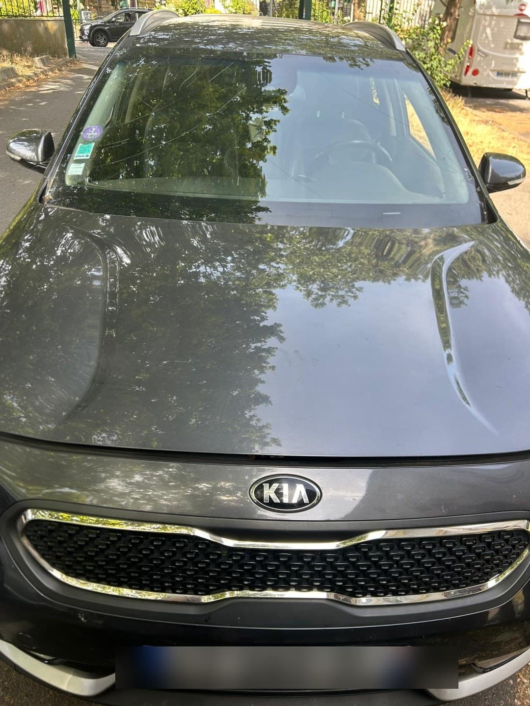 Kia XCeed grise, intervention en bord de rue sous les arbres : le véhicule reste là où il est garé