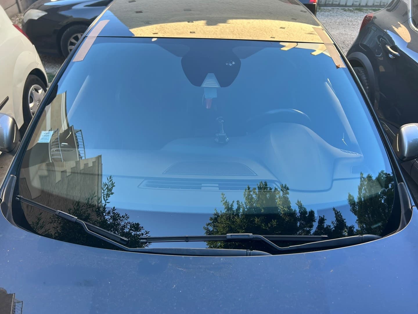 Renault Mégane IV, vitrage neuf en place, adhésifs de maintien encore posés en haut de baie