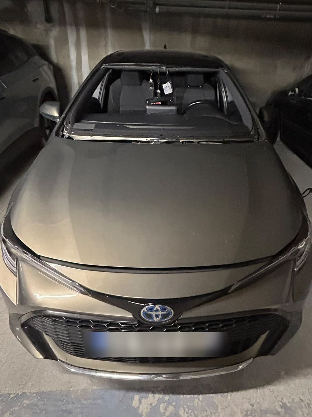 Toyota Corolla hybride en parking souterrain, pare-brise déposé