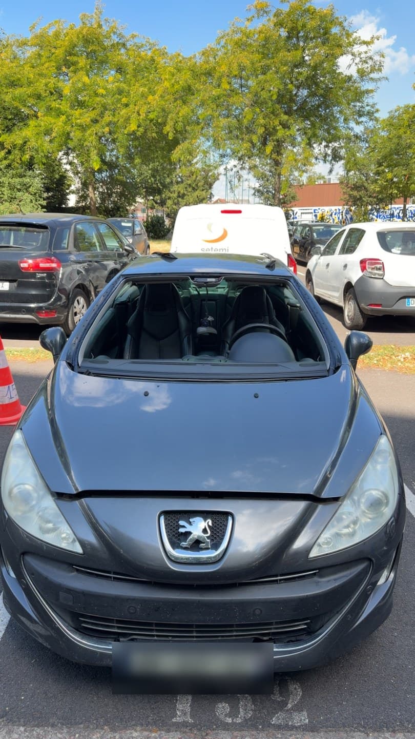 Peugeot 308 CC grise, pare-brise déposé : la baie est nue, prête à recevoir le vitrage neuf