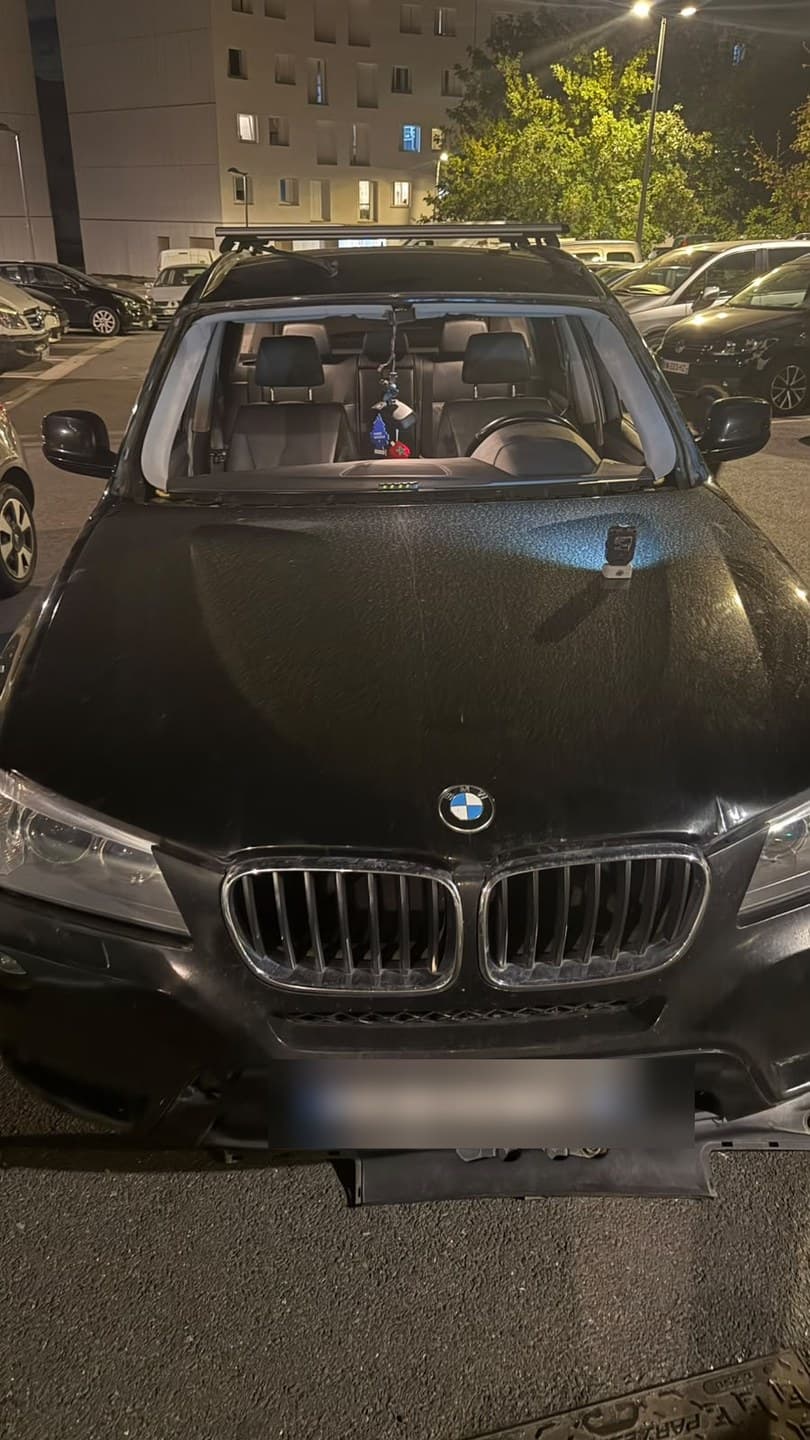 BMW X3 noire, intervention de nuit sur un parking : pare-brise déposé, baie entièrement dégagée