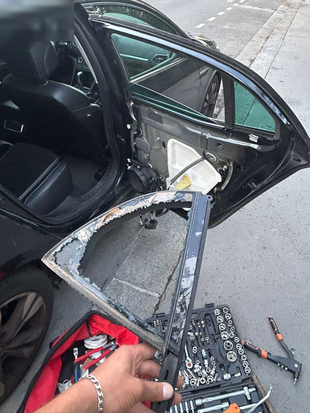 Peugeot berline noire, custode arrière brisée : garniture de porte déposée et ancien vitrage retiré sur place